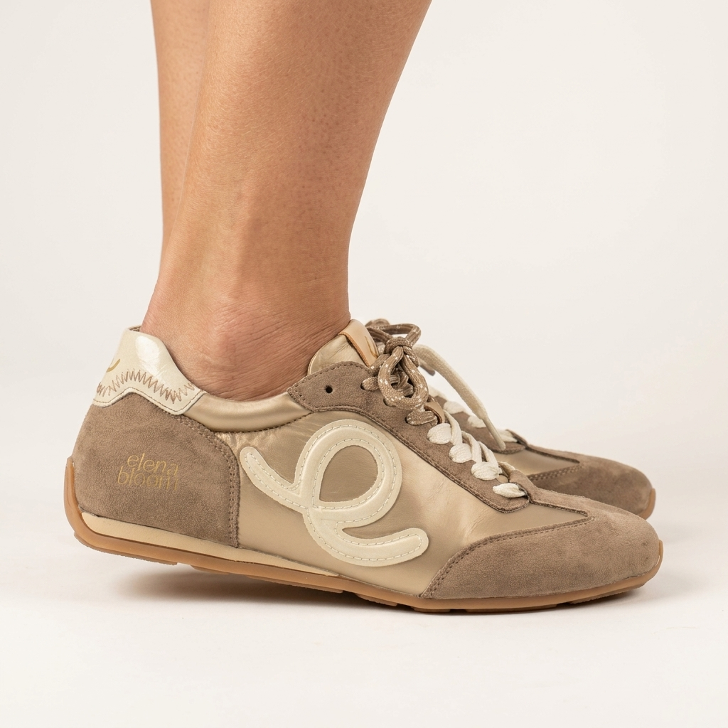 Sapatilha feminina Elena Bloom taupe calçada, vista de perfil sobre fundo claro, com painel creme, logótipo «e» e sola caramelo