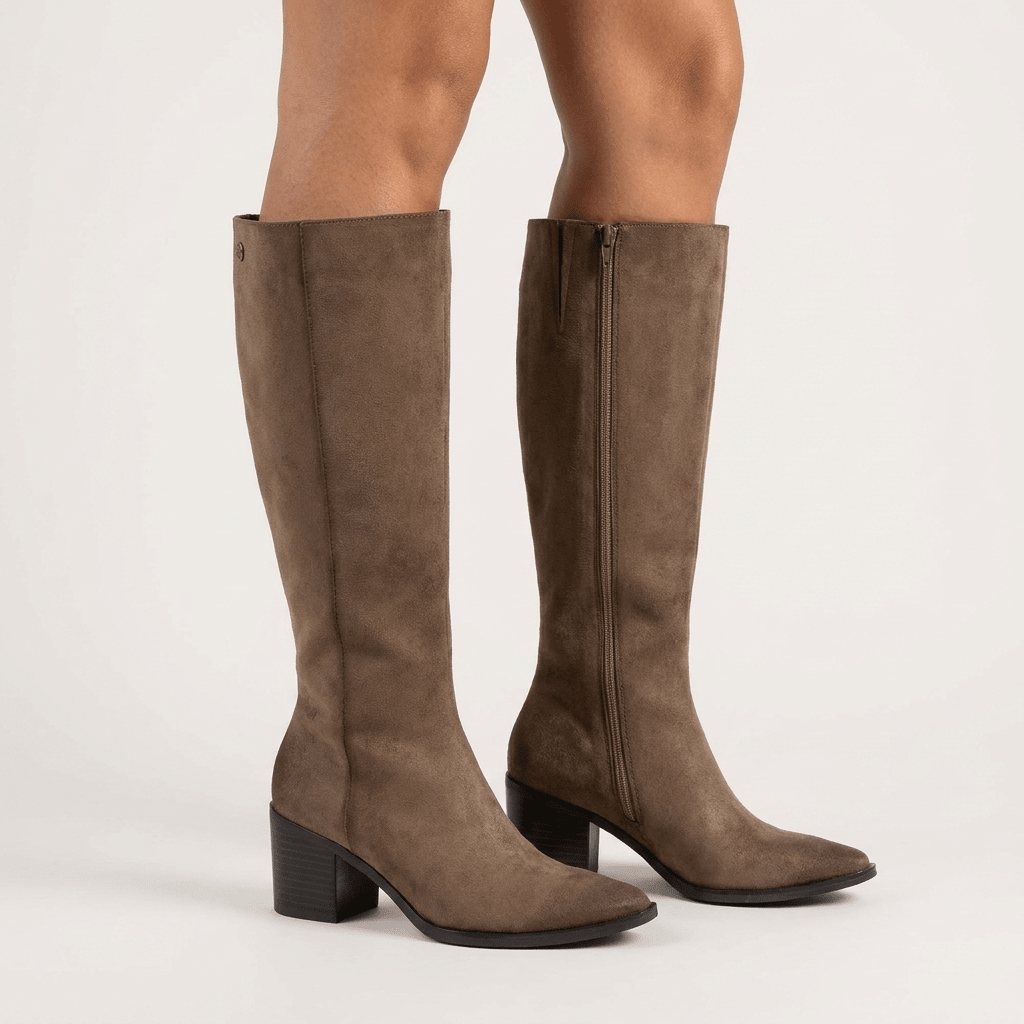 Par de botas XTi taupe em antelina, de cano alto e tacão largo, em estúdio sobre fundo claro, com o fecho de correr interior visível numa das botas