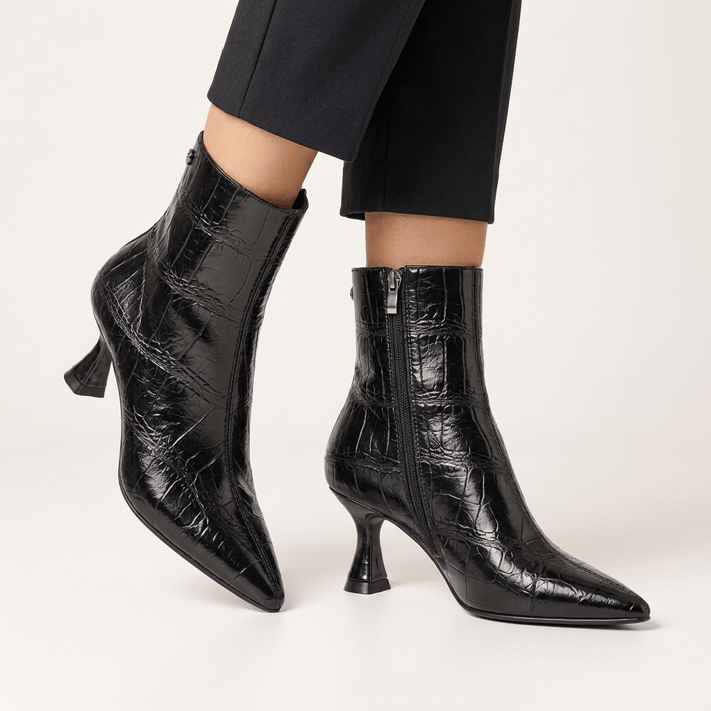 Pormenor dos botins XTi pretos efeito croco com fecho de correr interior, calçados com calças pretas