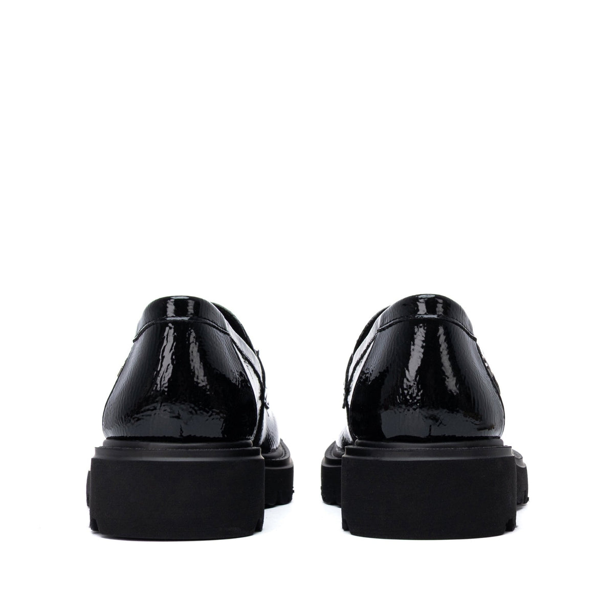 Par de Mocassins Carmela em verniz preto com sola grossa, vista traseira dos dois sapatos em fundo branco