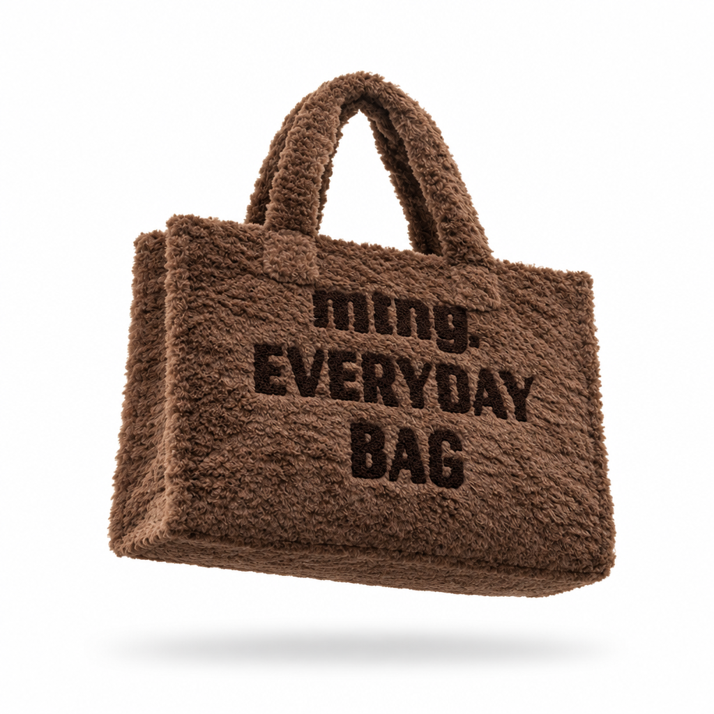 Packshot da Mala Tote Mustang Fey castanho em pelo suave, vista frontal em levitação com a mensagem mtng. Everyday Bag em tom chocolate, fundo branco