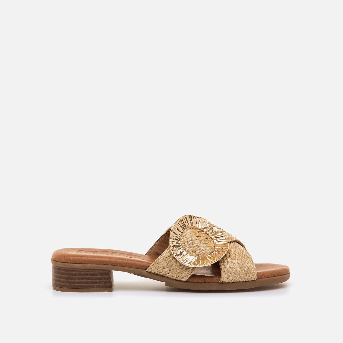 Sandália mule Mustang Agnes em ráfia entrançada bege natural com aplique circular dourado e salto bloco de 4 cm, sobre fundo branco.