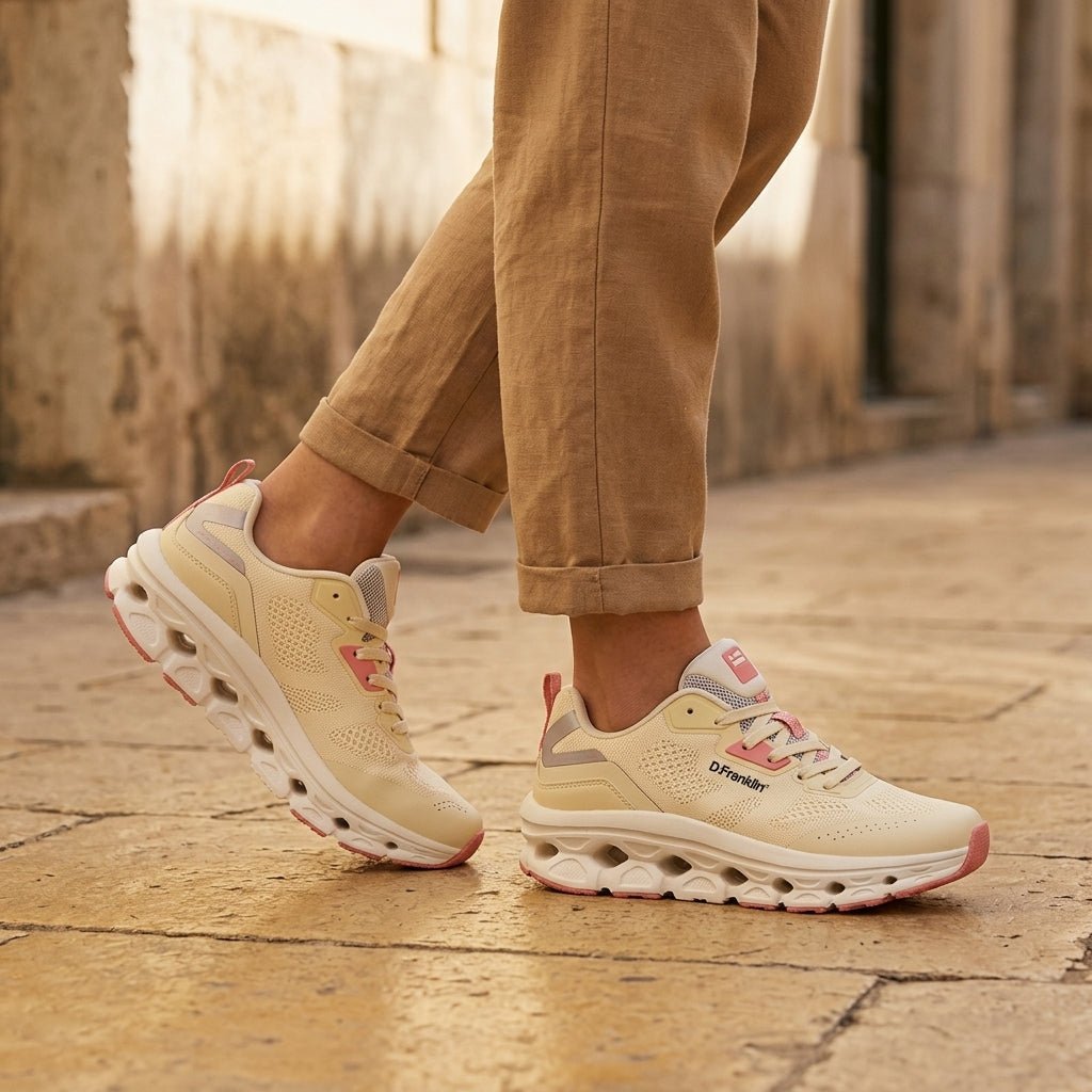 Pés calçados com sapatilhas D. Franklin Aero Dual bege, em passeio de calçada, look casual com calças castanhas
