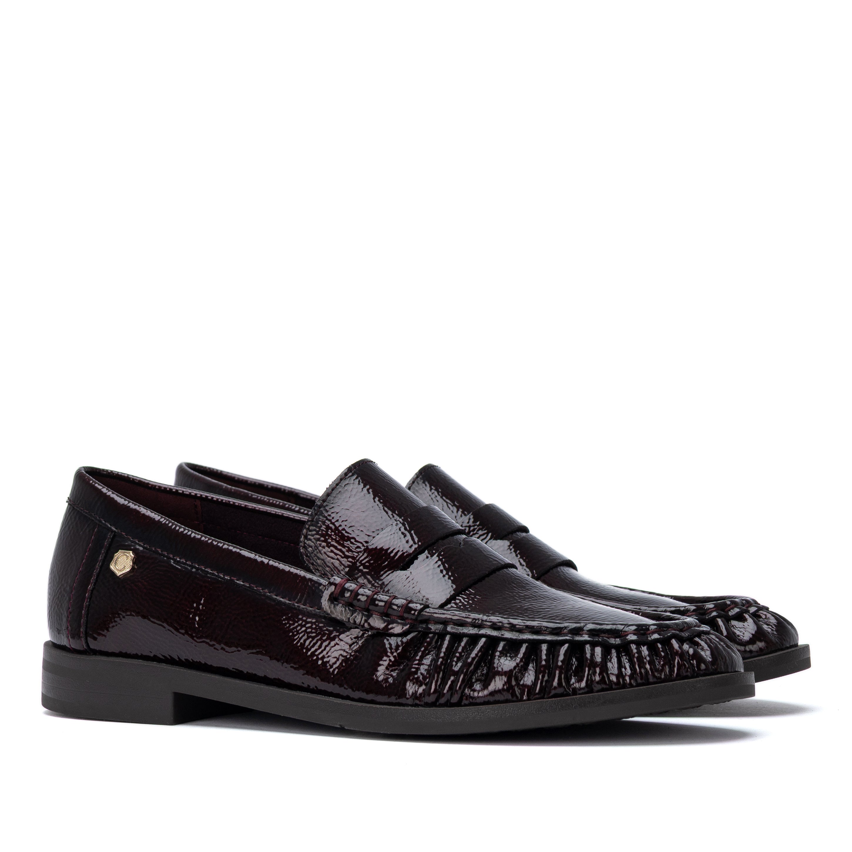 Par de mocassins Carmela pele envernizada bordeaux, vista lateral sobre fundo branco