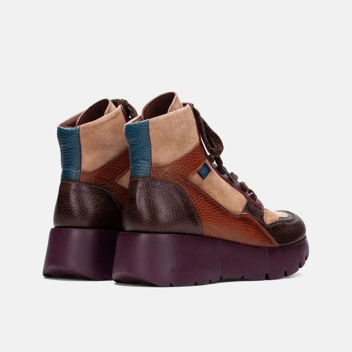 Par de botins Sport Hispanitas Chocolate-Amêndoa-Bordô visto de trás, em fundo neutro de estúdio, mostrando o painel traseiro em camurça amêndoa com friso azul petróleo e a sola bordô robusta.
