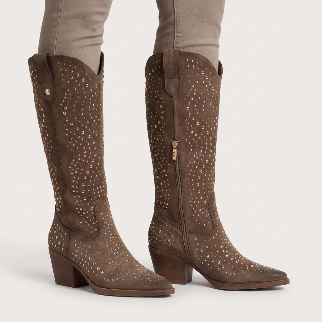 Par de botas texanas XTi taupe em antelina com tachas metálicas e fecho interior, com calças cinzentas