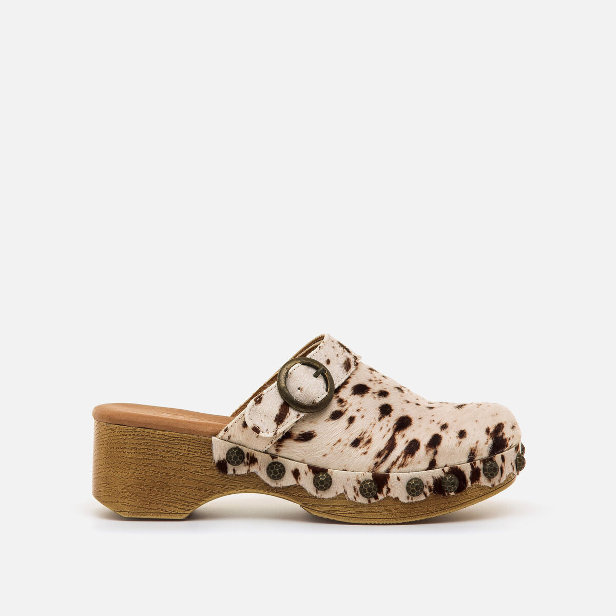 Tamancos Mustang Elois com estampa de vaca em branco e castanho, plataforma efeito madeira e salto alto — vista frontal.