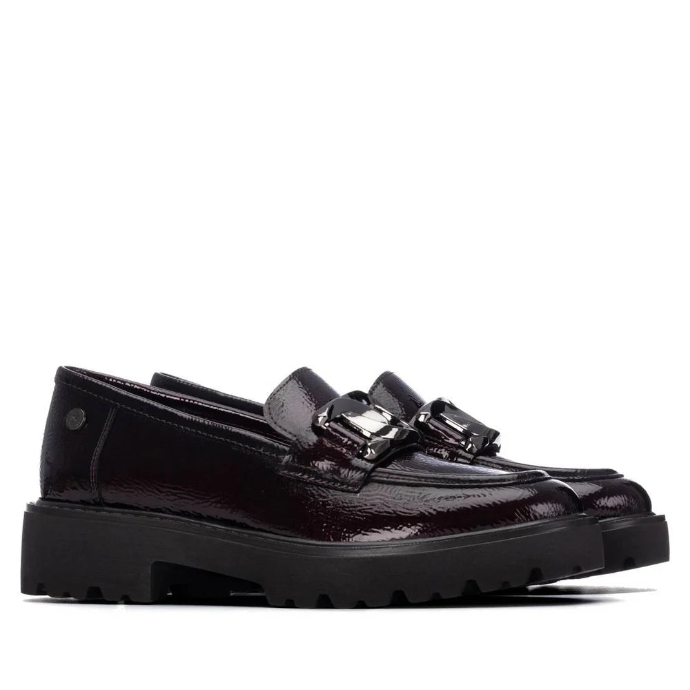 Par de Mocassins XTI Bordeaux em pele envernizada, vista lateral em estúdio, com fivela metálica cravejada e sola grossa.