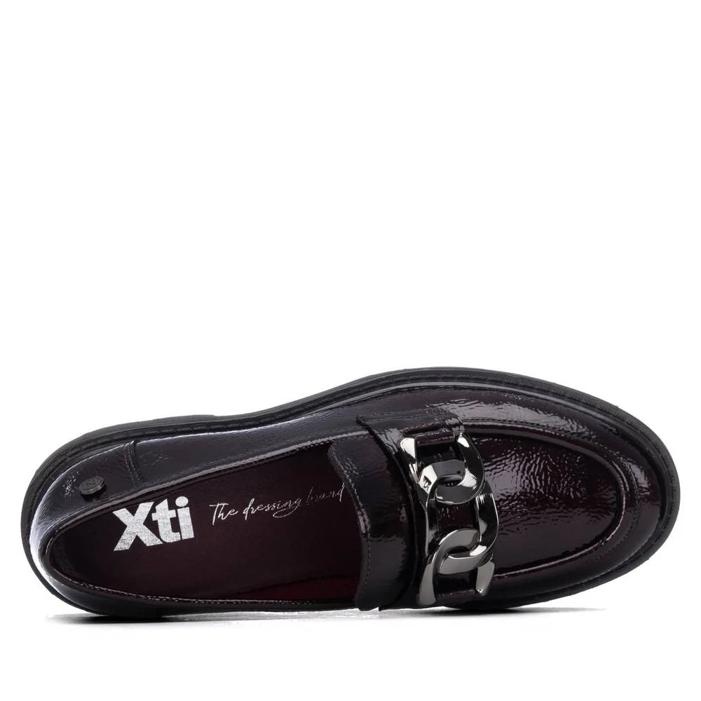 Mocassim XTI Bordeaux em pele envernizada visto de cima, mostrando a palmilha com o logótipo Xti e a fivela em corrente metálica.