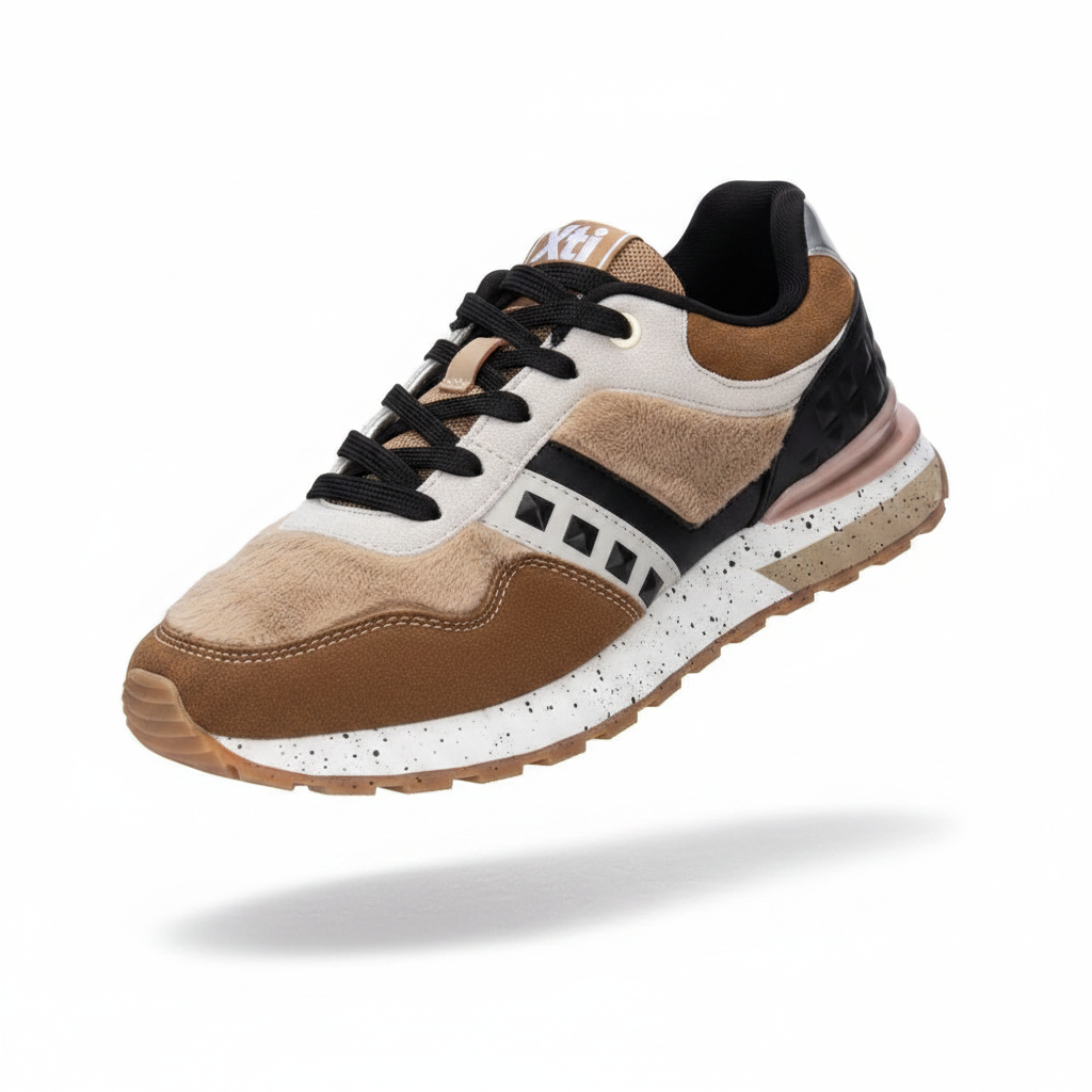Sapatilha XTI castanho e branco estilo retro runner, vista em perspetiva sobre fundo branco, com painéis em camurça castanho, branco e preto, detalhes tipo pelo e sola desportiva salpicada.