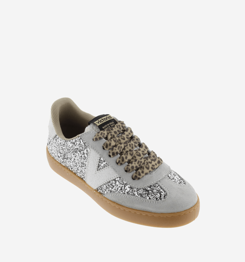 Ténis Victória glitter prateado, vista frontal em ângulo elevado, atacadores animal print, etiqueta Victoria na língua
